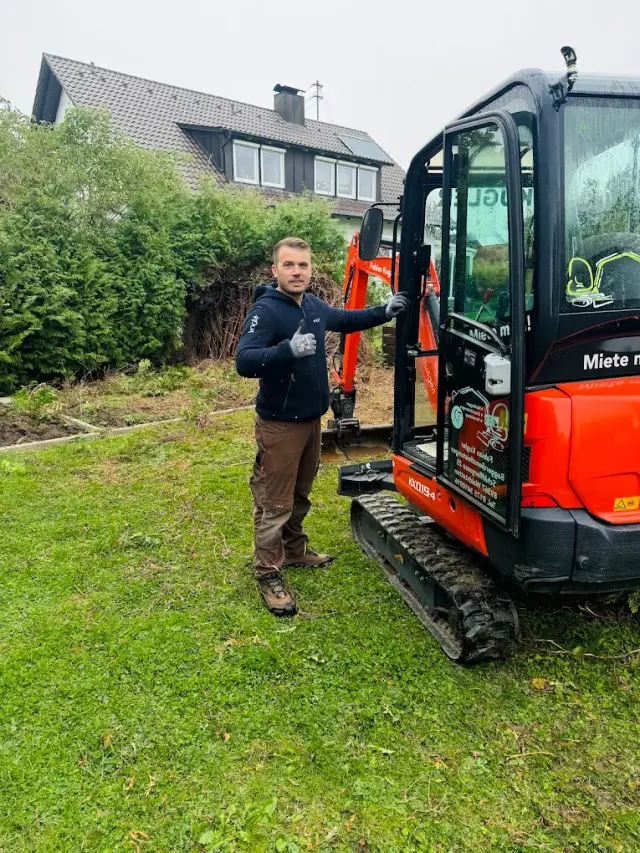 Mitarbeiter von Shala Dienstleistungen neben einem Minibagger im Garten