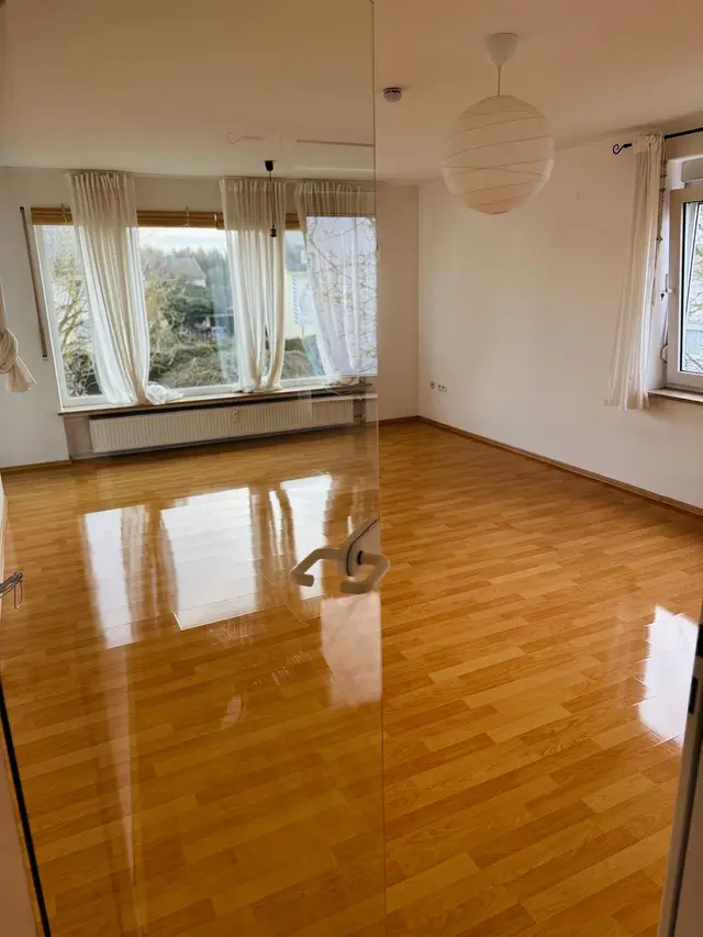 Frisch gereinigter, glänzender Holzboden in einem hellen Zimmer