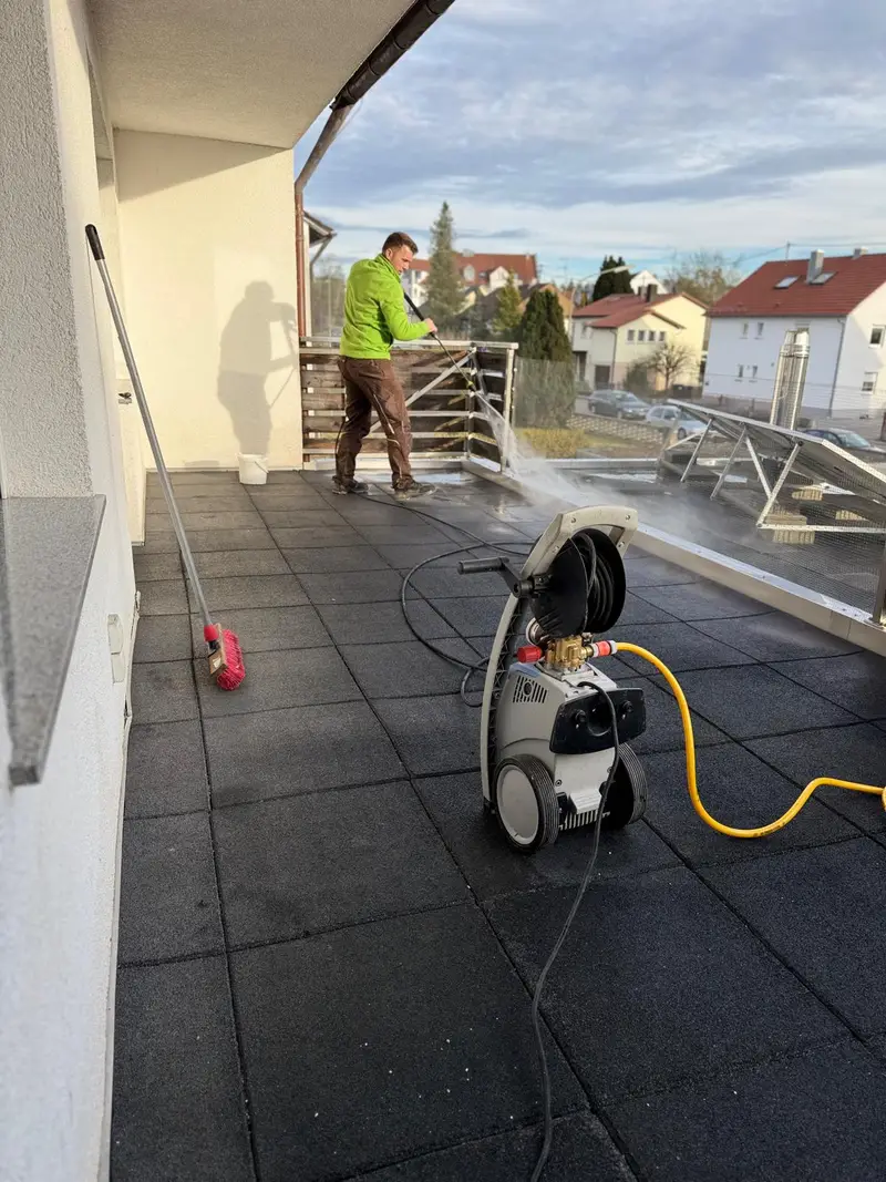 Mitarbeiter reinigt eine Dachterrasse mit dem Hochdruckreiniger