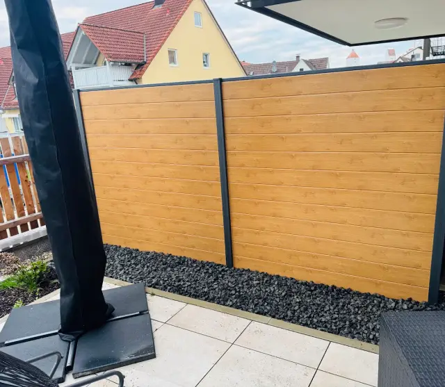 Sichtschutzzaun in Holzoptik mit anthrazitfarbenen Pfosten an einer Terrasse
